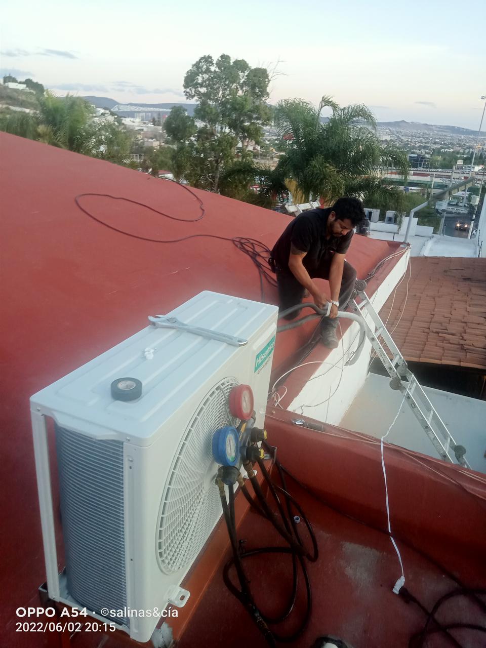 Técnico trabajando con manómetros en azotea de Querétaro.